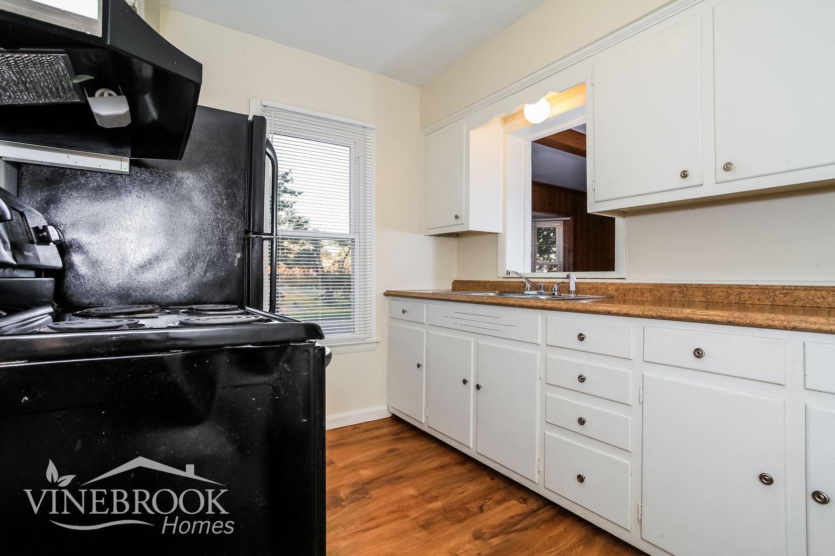 a kitchen with white cabinets and a black stove and refrigerator