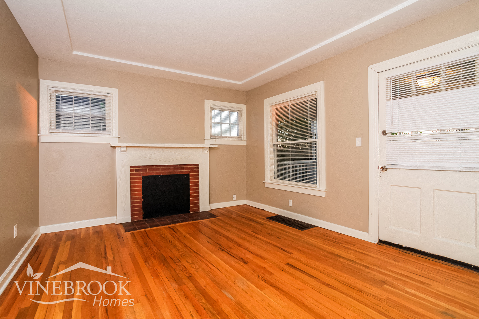 a living room with wood floors and a fireplace