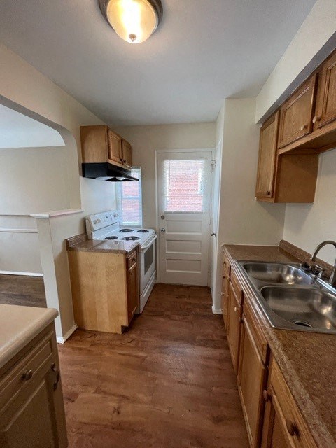 A kitchen with wooden cabinets and a stove top oven.