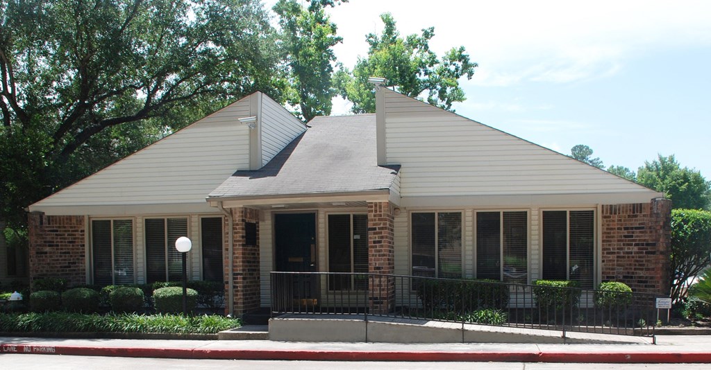 a small brick building with a black fence in front of it