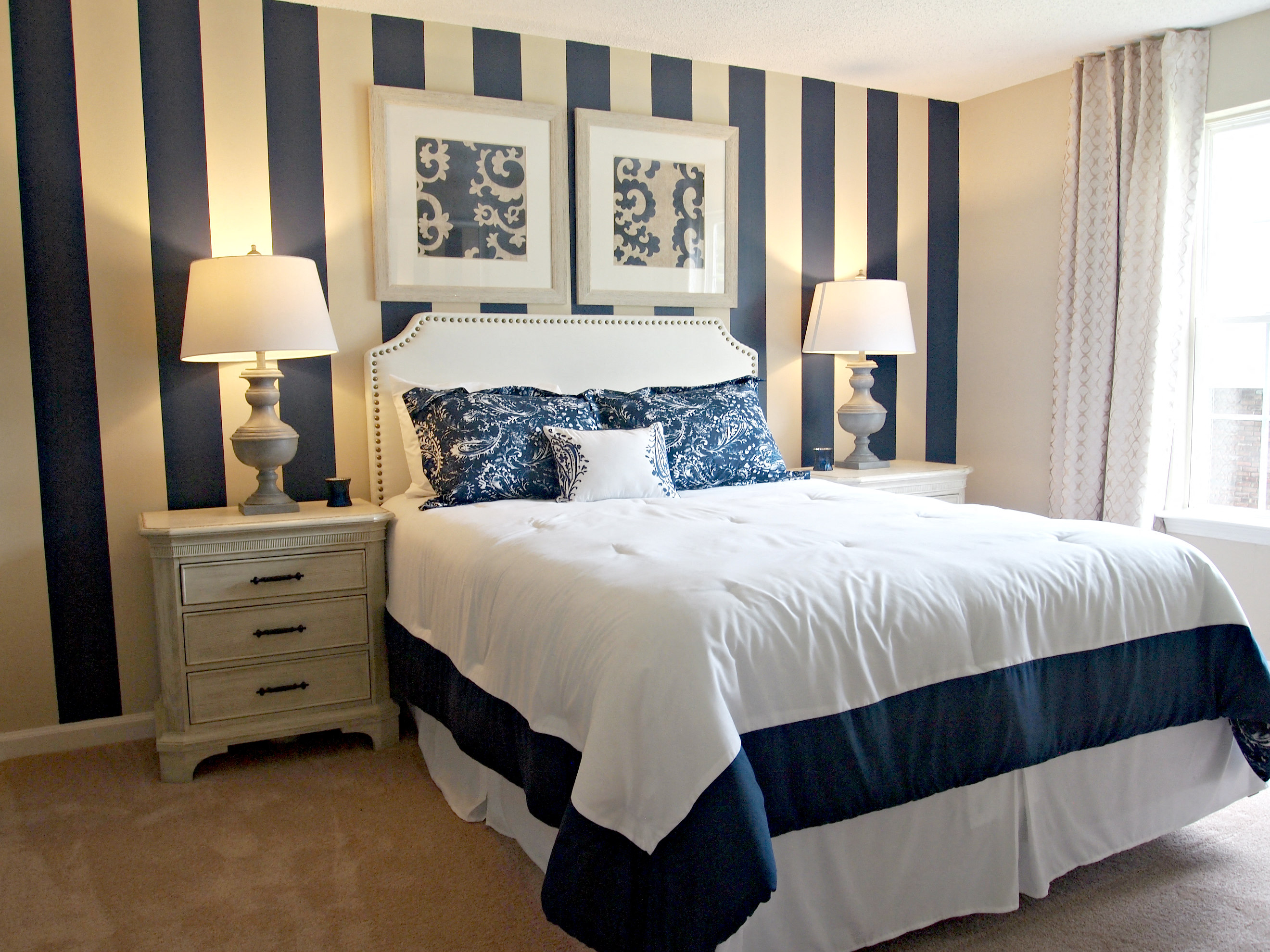 a bedroom with a bed and a striped wall