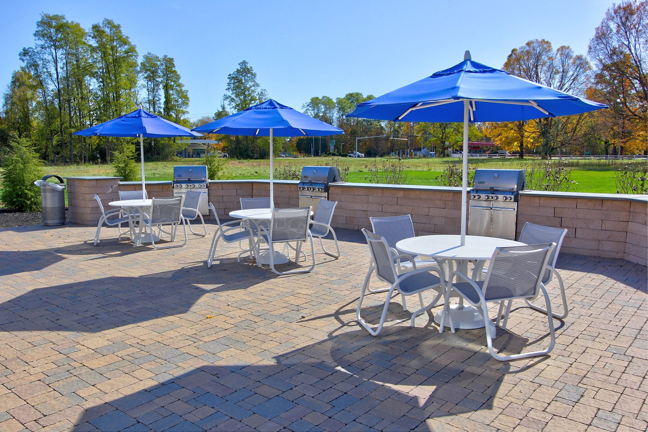 a patio with tables and chairs with umbrellas
