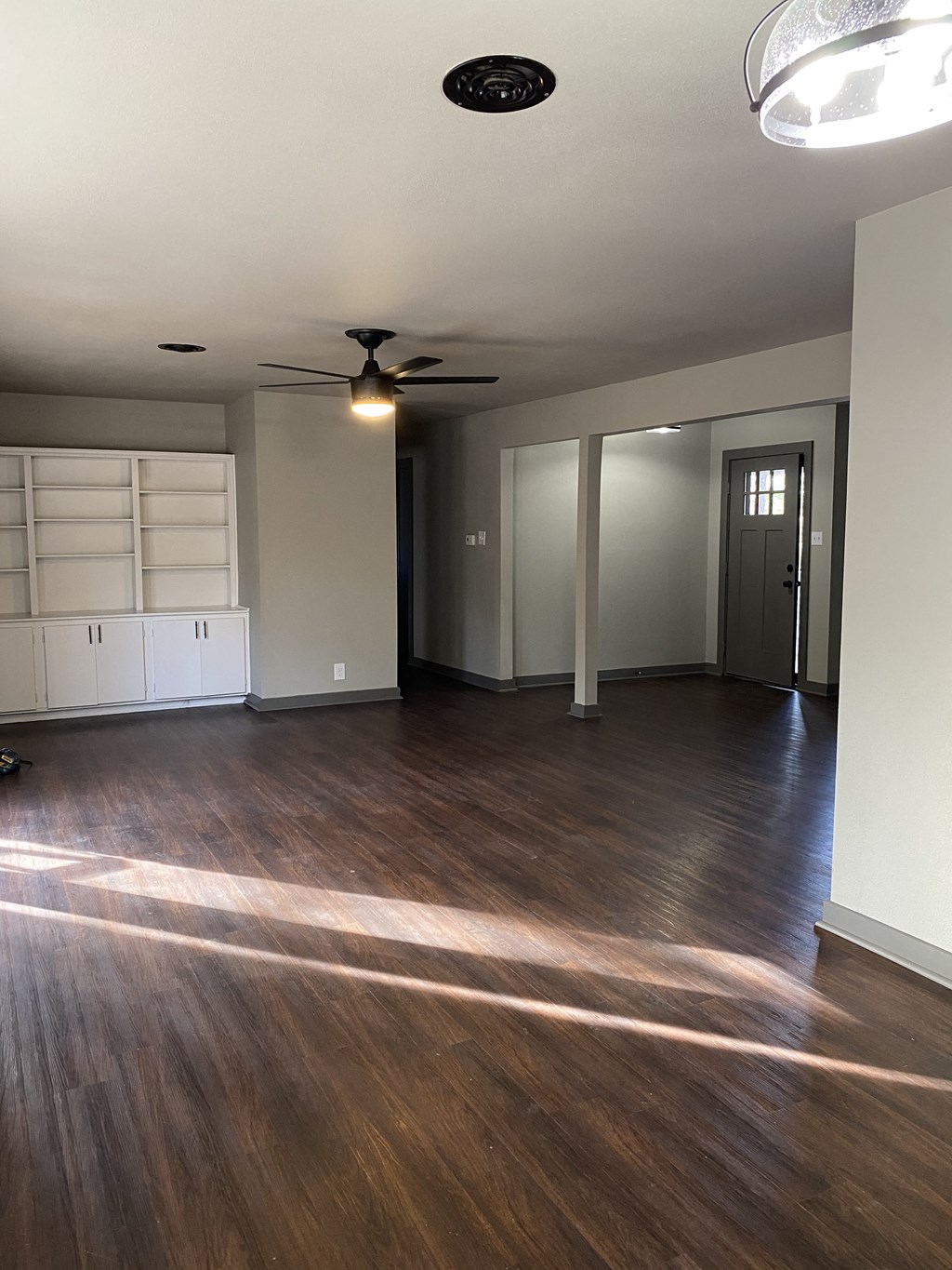 A room with a ceiling fan and a door.