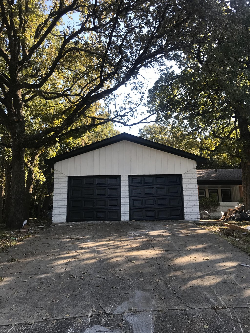 A garage with two doors is surrounded by trees.
