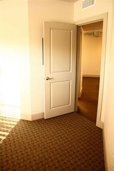 a hallway with a white door and a carpet