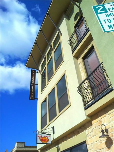 a tall building with a balcony and a street sign