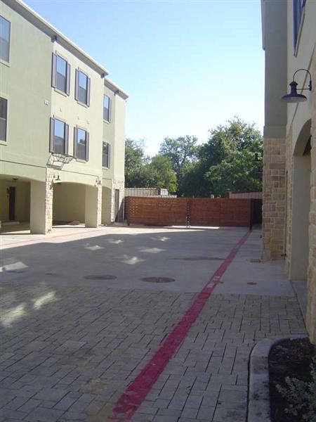 an empty street with a brick sidewalk and a building