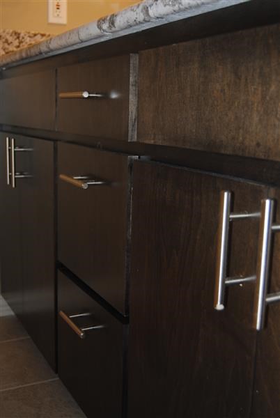 a kitchen with wooden cabinets and stainless steel drawers
