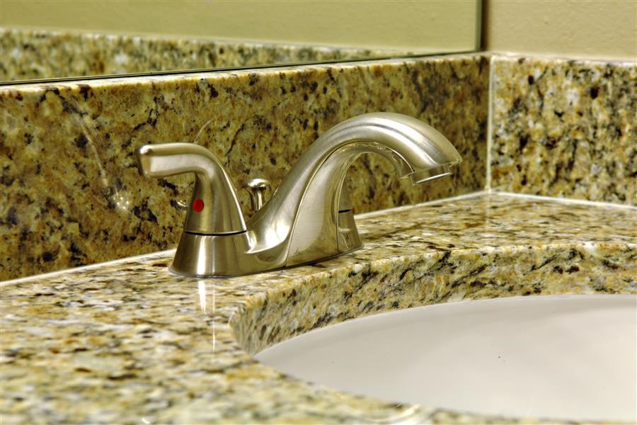 a bathroom sink with a faucet on a granite counter top