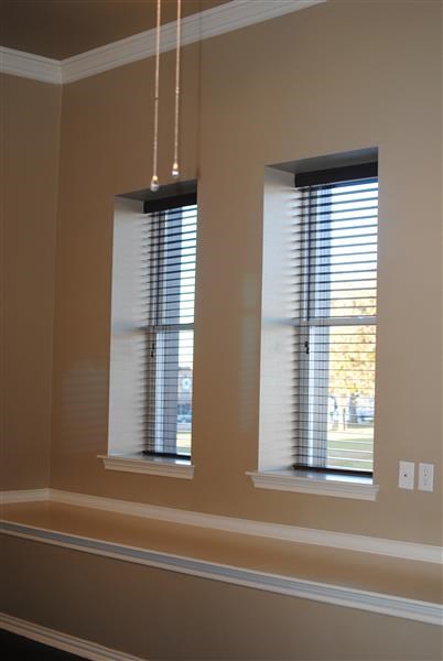 a living room with two windows with blinds
