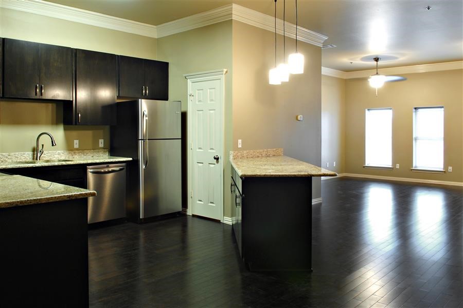 an empty kitchen with a stainless steel refrigerator
