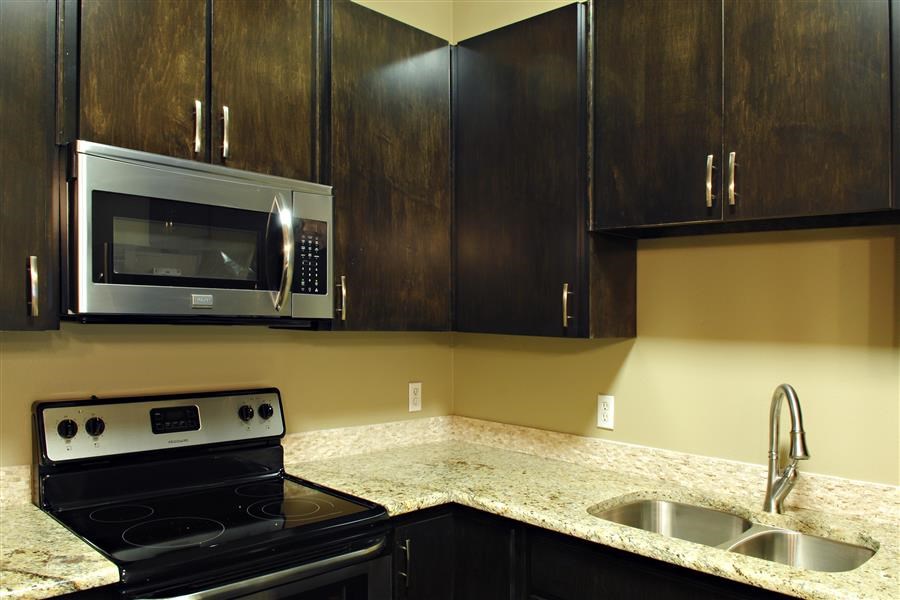 a kitchen with a stove and a sink and a microwave