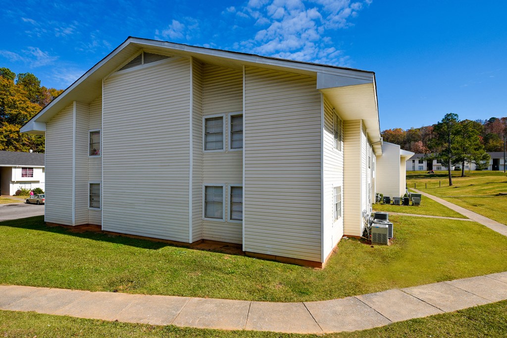 A white house with a grey roof and a grey garage door.