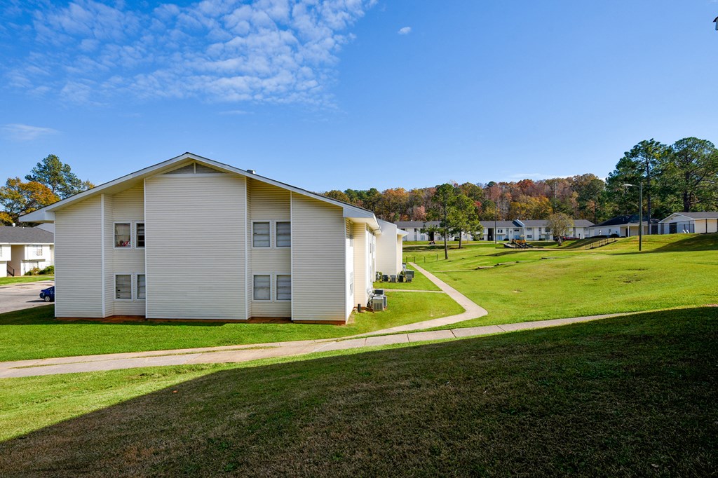 A white house with a green lawn in front.