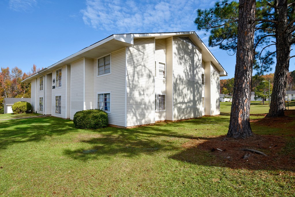 A white house with a tree in front of it.