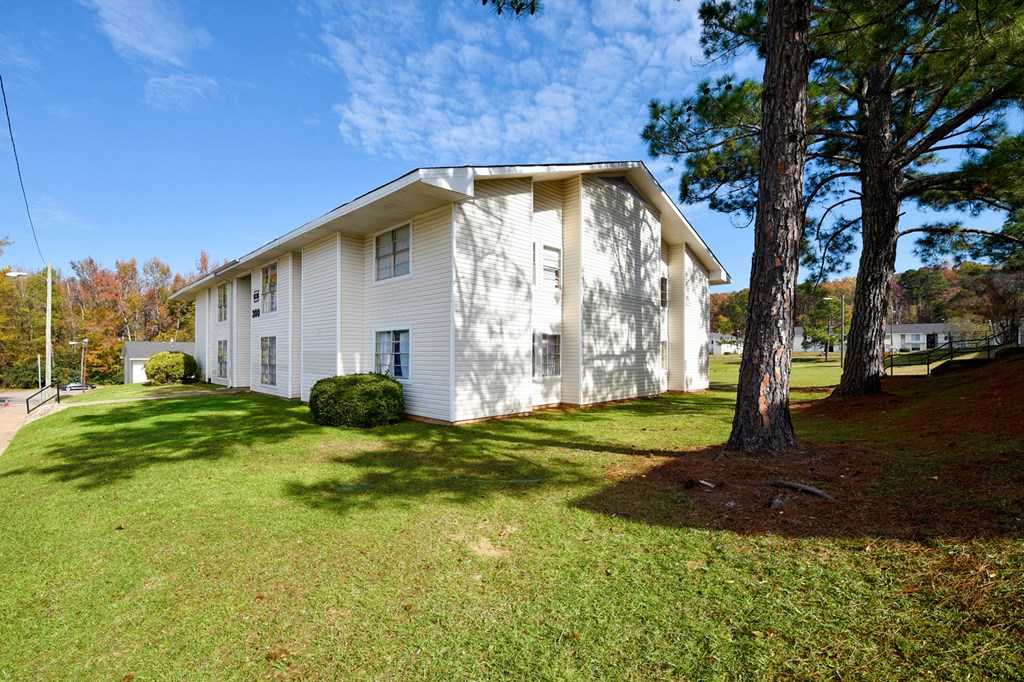 A white house with a tree in front of it.