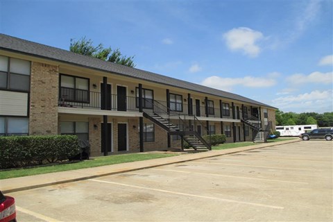 an apartment building with a parking lot and stairs