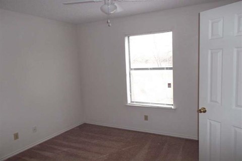 an empty room with a window and a door