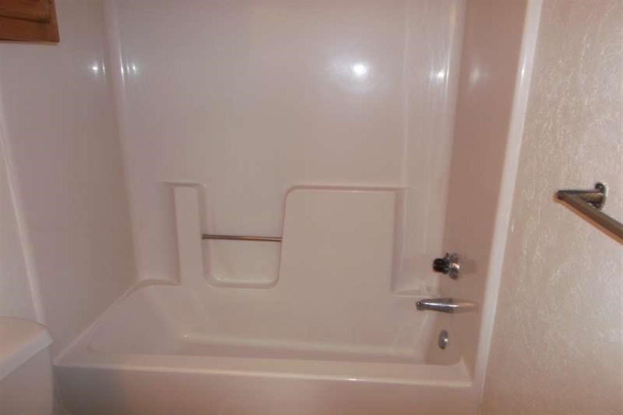 a white bathroom with a shower and a toilet