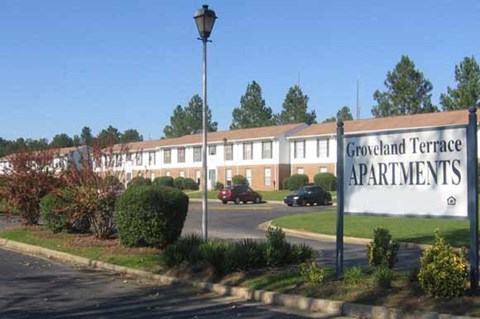 Groveland Terrace Apartments is a large apartment complex with a parking lot in front.
