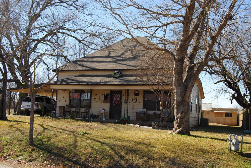 the front of a house with a yard and trees
