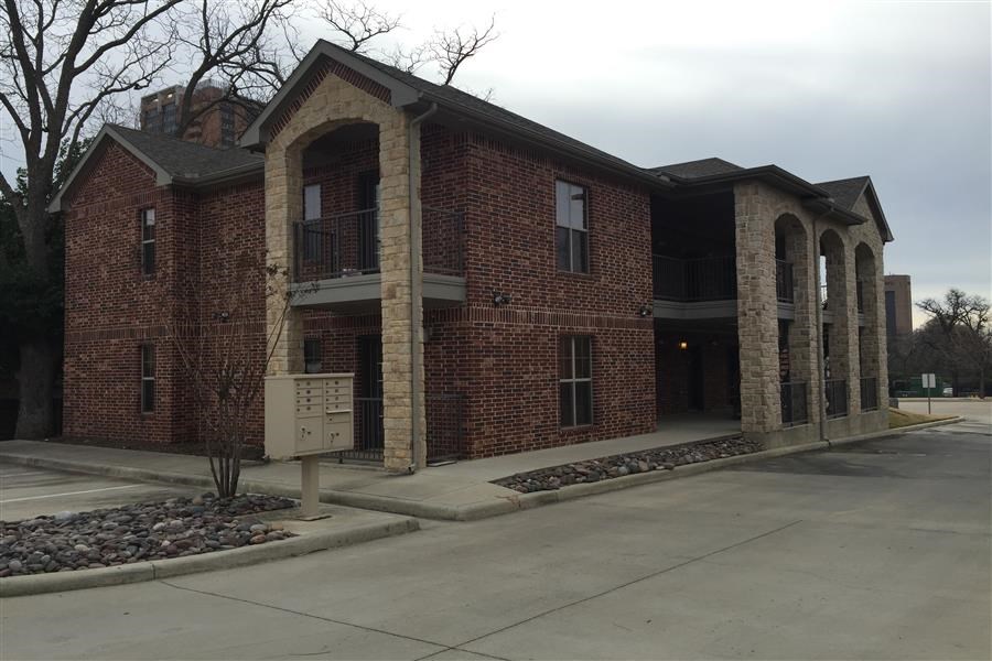 a large brick building with a parking lot
