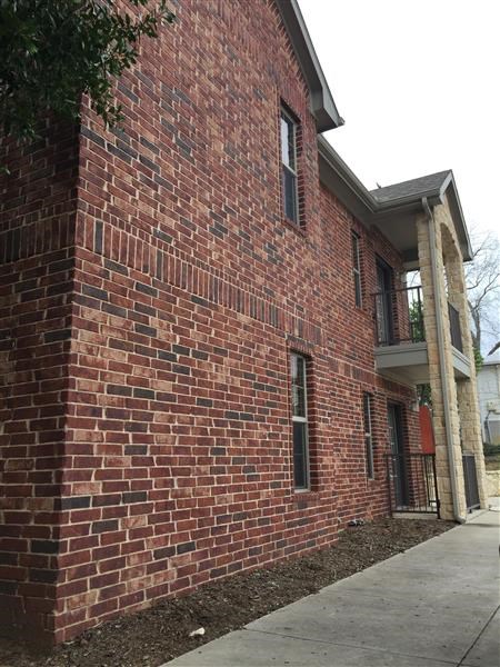 a brick building with a sidewalk in front of it