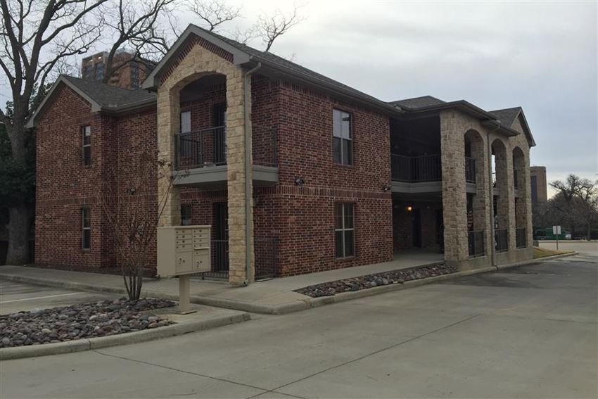 the front of a brick building with a parking lot