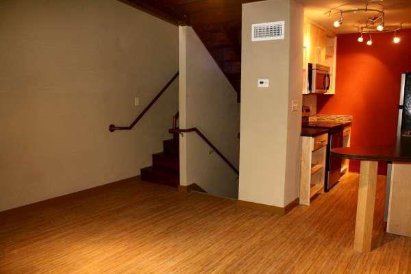 a living room with a staircase and a wooden floor