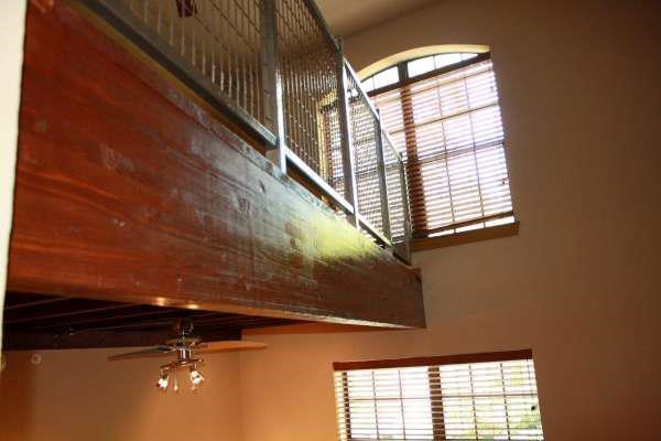 a room with a large wooden railing and a window