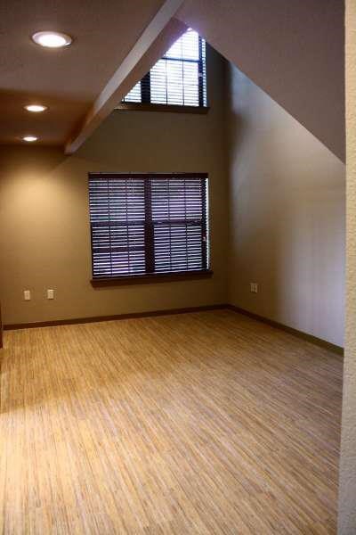 an empty living room with a wooden floor and a window