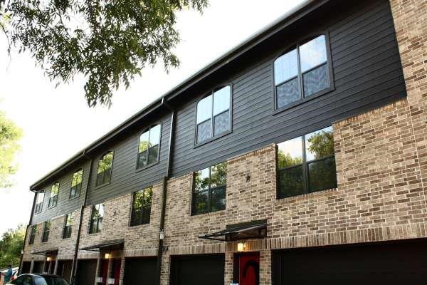 a brick building with a gray roof and windows