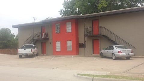 a red building with two cars parked in front of it