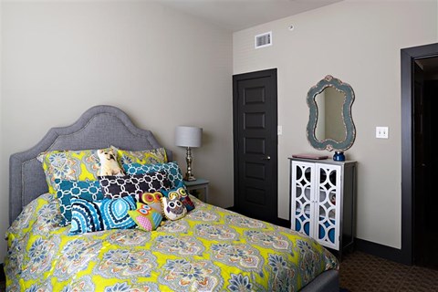 a bedroom with a bed with a yellow and blue comforter