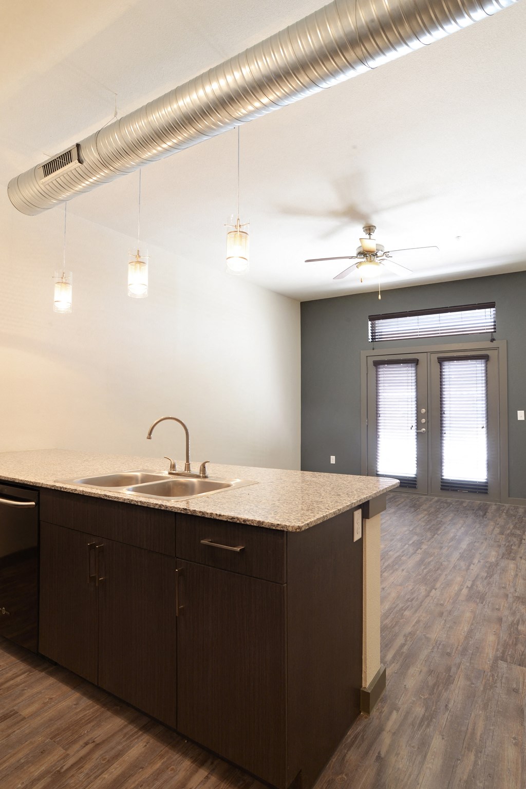 an empty kitchen with a sink and a ceiling fan