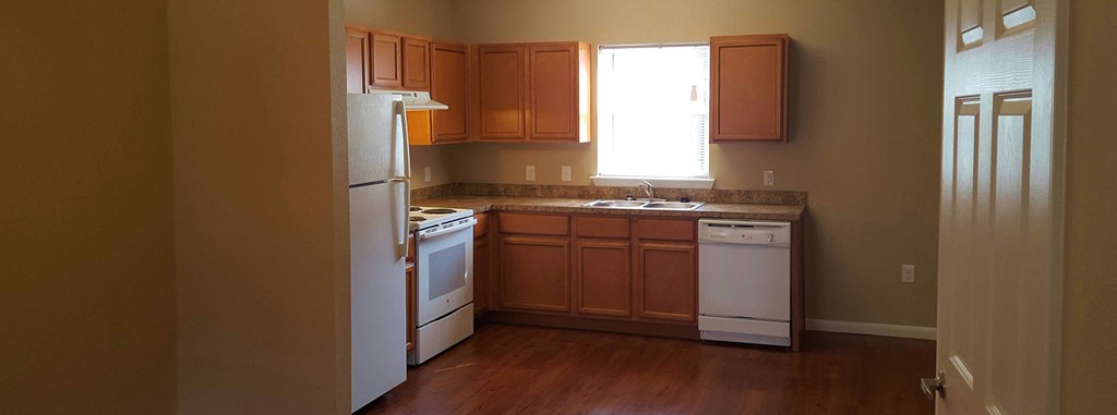 a kitchen with white appliances and wooden cabinets
