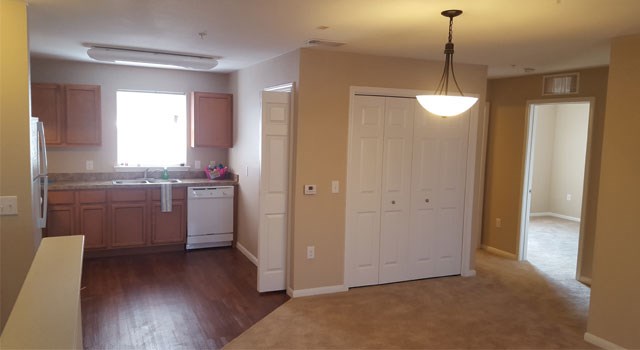 an empty kitchen and dining room with a door to the living room