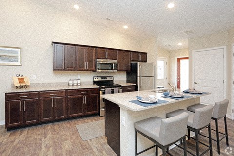 A kitchen with brown cabinets and a white island.