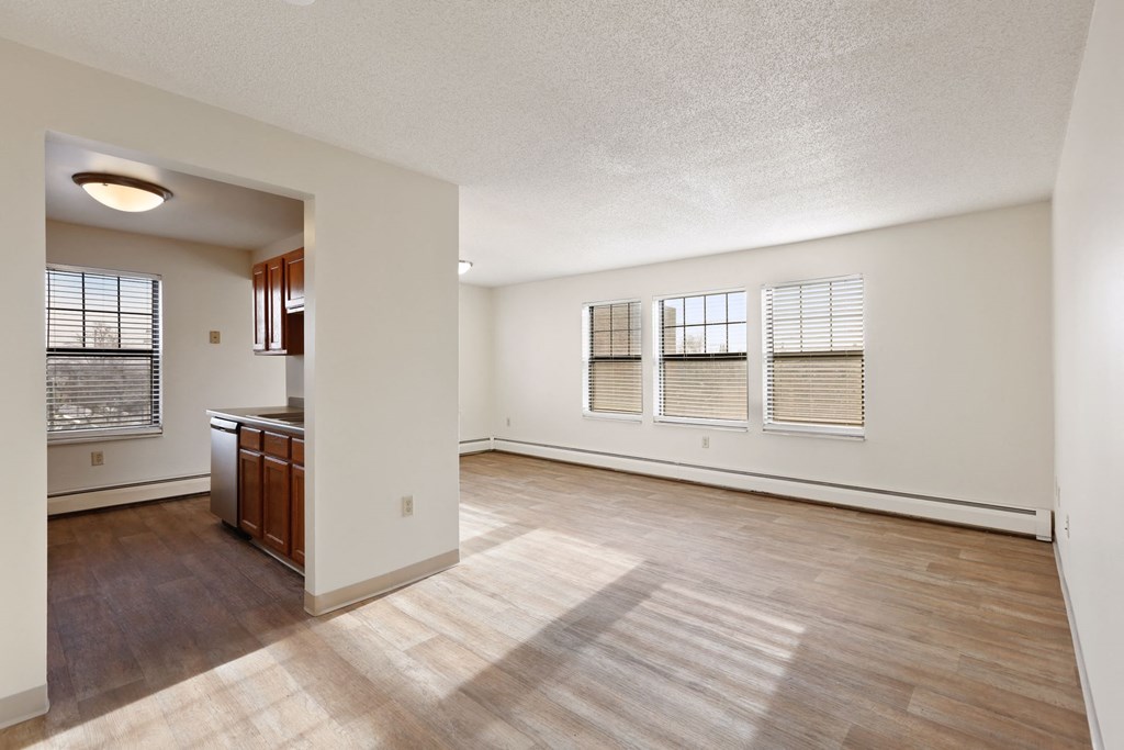 the living room and kitchen of an empty apartment