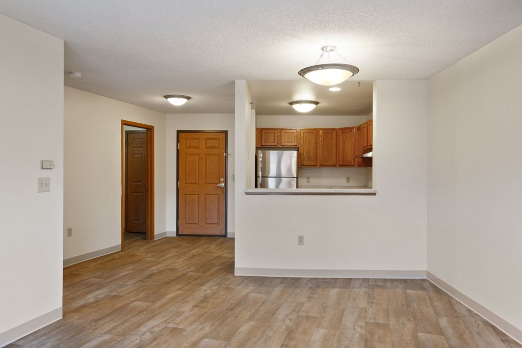 the living room and kitchen of an empty apartment