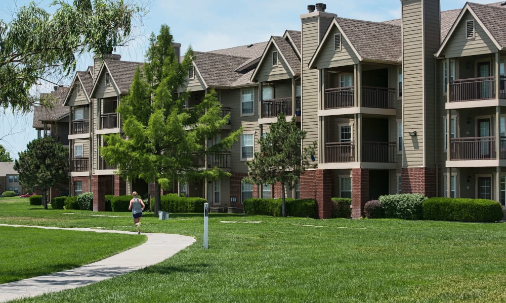 a person walking down a sidewalk in front of an apartment building