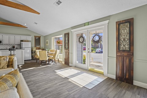 the living room and dining room of a house with large windows and doors