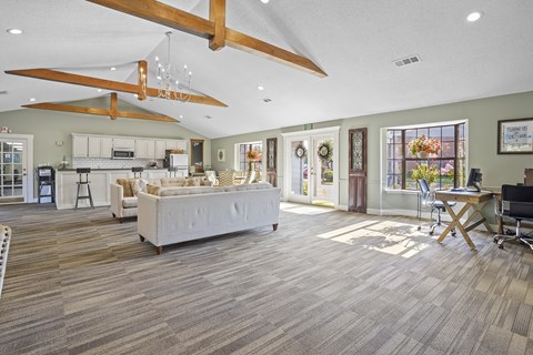 a living room with a white couch and a kitchen