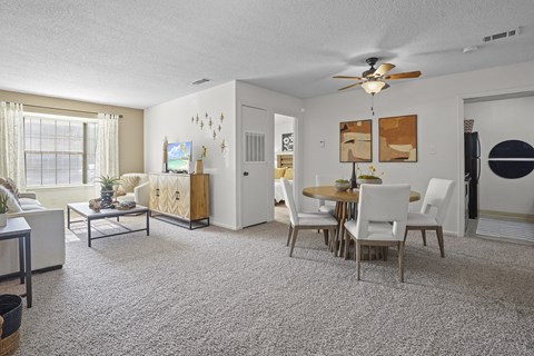 an open living room and dining room with a table and chairs and a ceiling fan