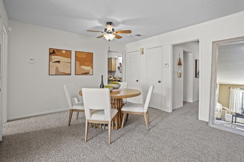 a dining room with a table and chairs and a ceiling fan