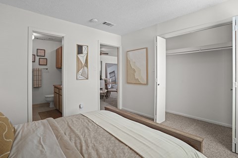 a bedroom with a large bed and sliding glass doors to a bathroom