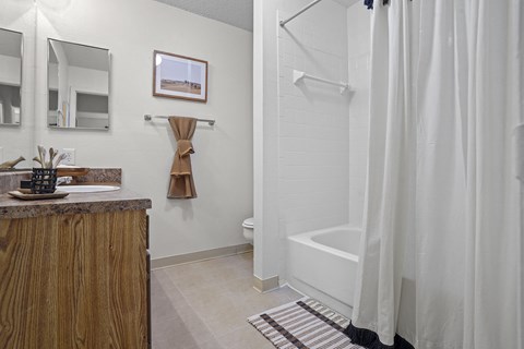 a bathroom with a shower and a sink and a shower curtain