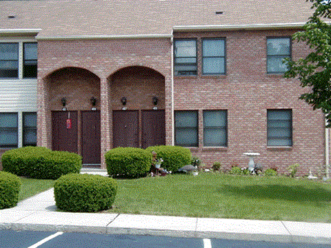 a brick building with a yard in front of it
