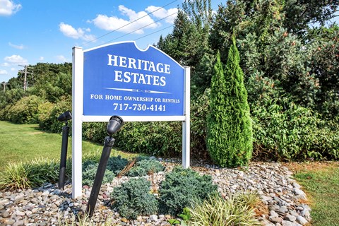 A sign for Heritage Estates is displayed in front of a well-manicured garden.