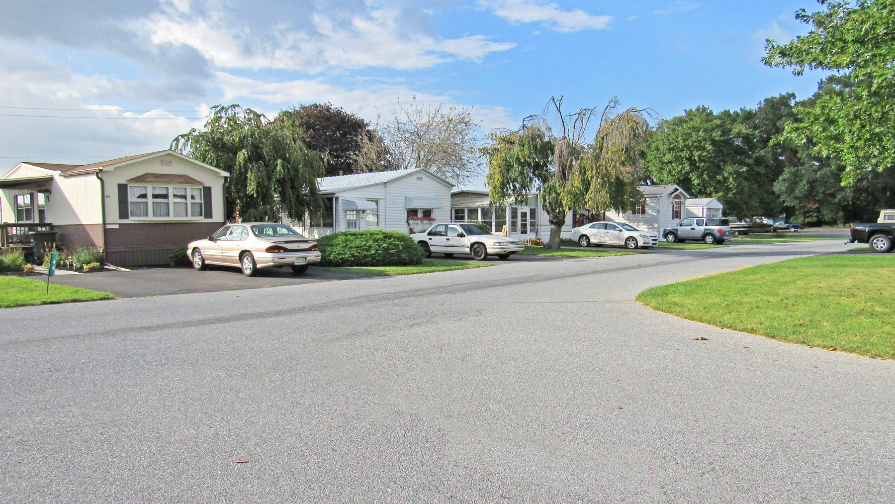 a street with cars parked in front of houses